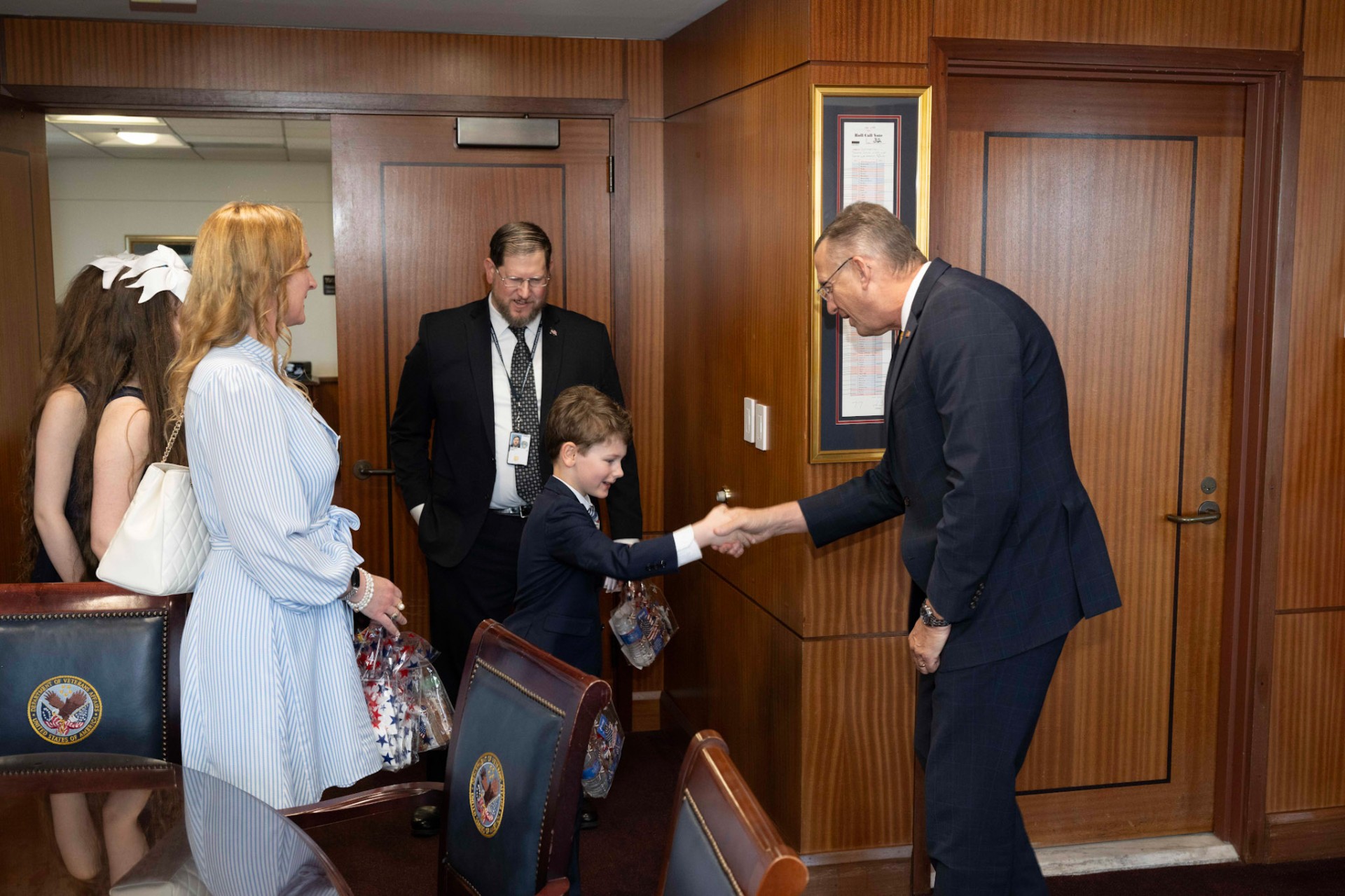 A young cotillion student shakes hands with the Secretary of Veterans Affairs
